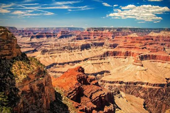 Layered red rock walls and buttes of the Grand Canyon under a blue Arizona sky