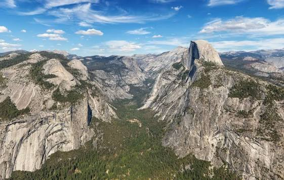 Granite cliffs of Yosemite Valley with El Capitan and Half Dome beneath a clear California sky